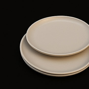Two beige ceramic plates stacked on a black background